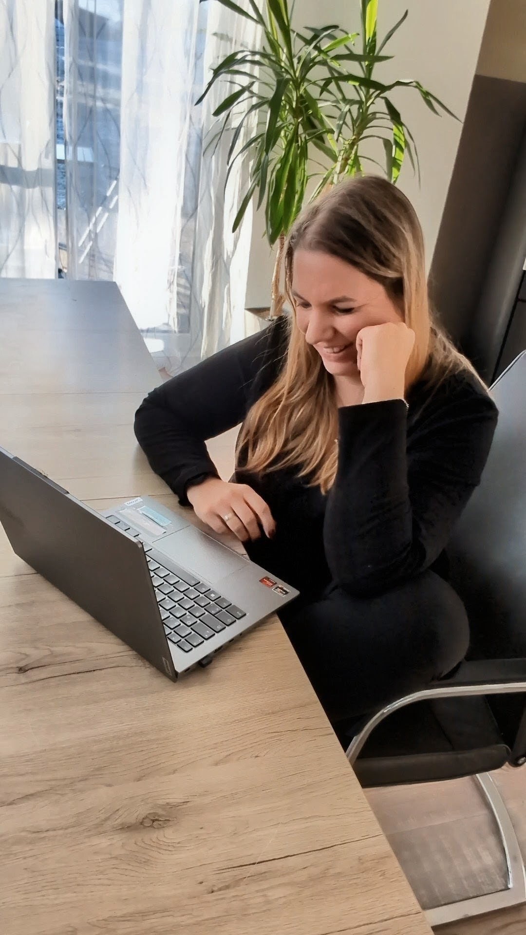 Dianne Pfaffenberger lächelnd am Laptop in ihrem Büro